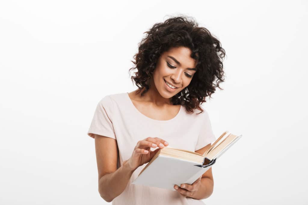 Portrait Of A Smiling Young Afro American Woman Reading A