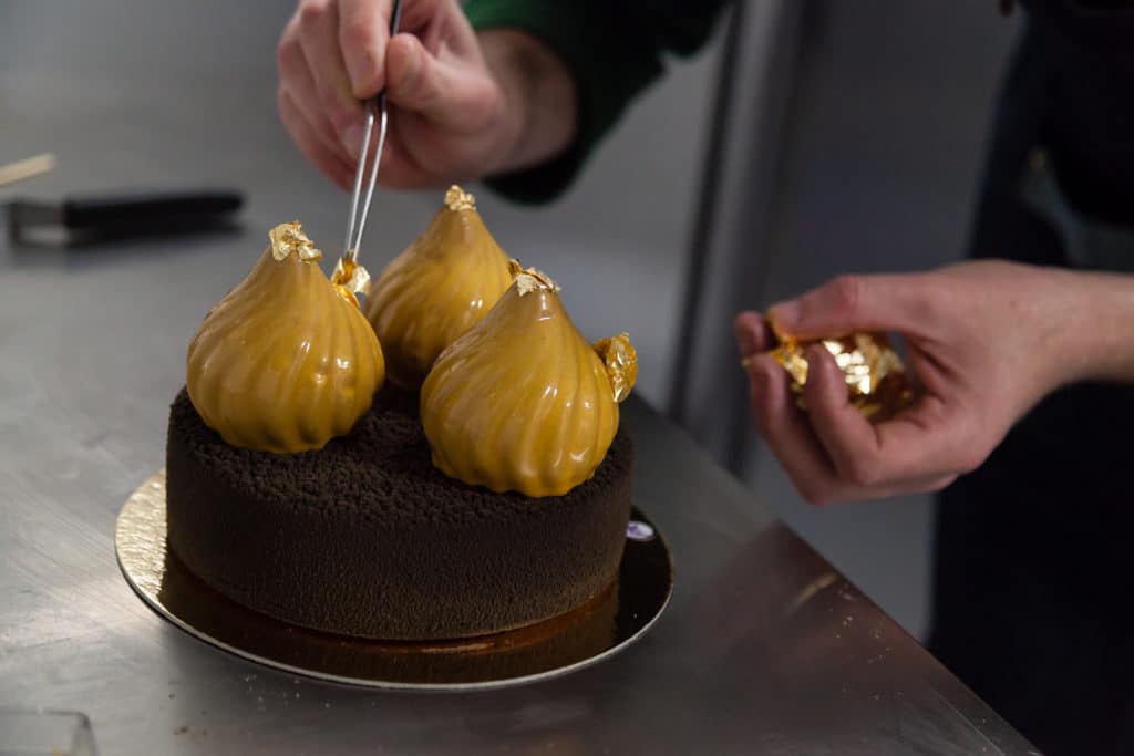 Hands Putting Edible Gold With A On A Creative Cake