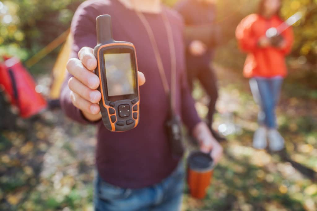 Picture Of Man Holding Satellite Phone And Thermocup In Hands.