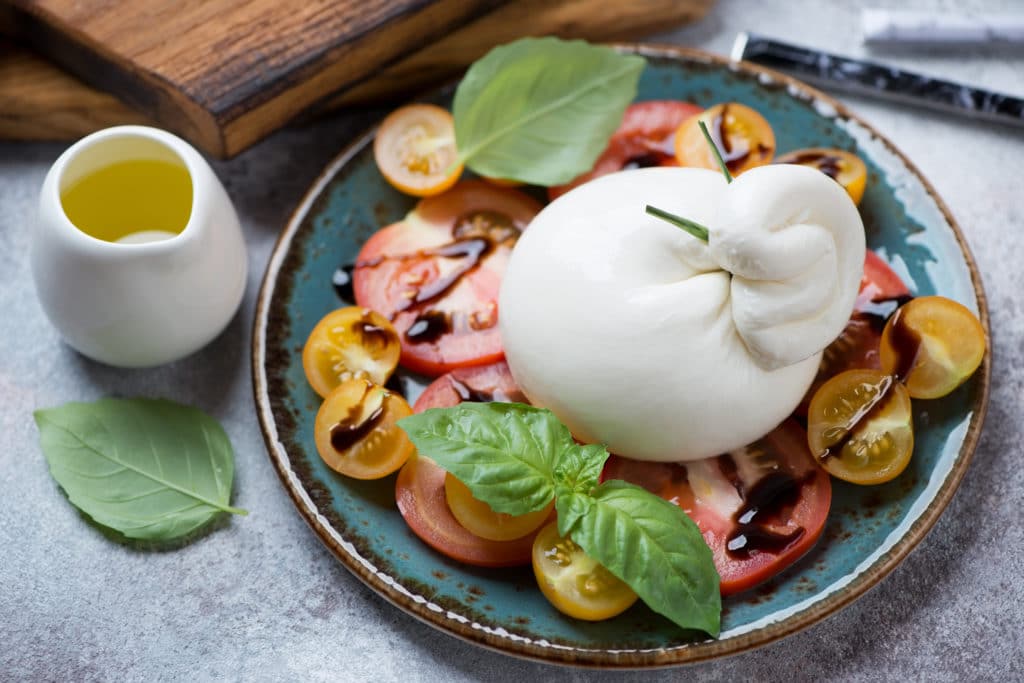 Burrata Cheese And Tomatoes Salad Served On A Turquoise Plate 