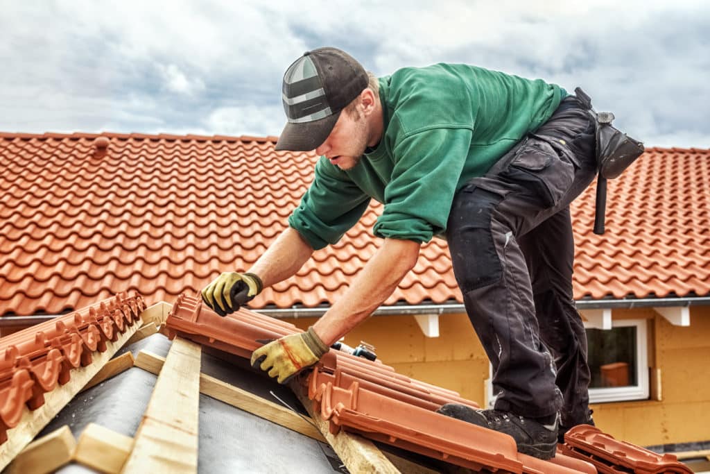 Roofer At Work Installing Clay Roof Tiles Germany