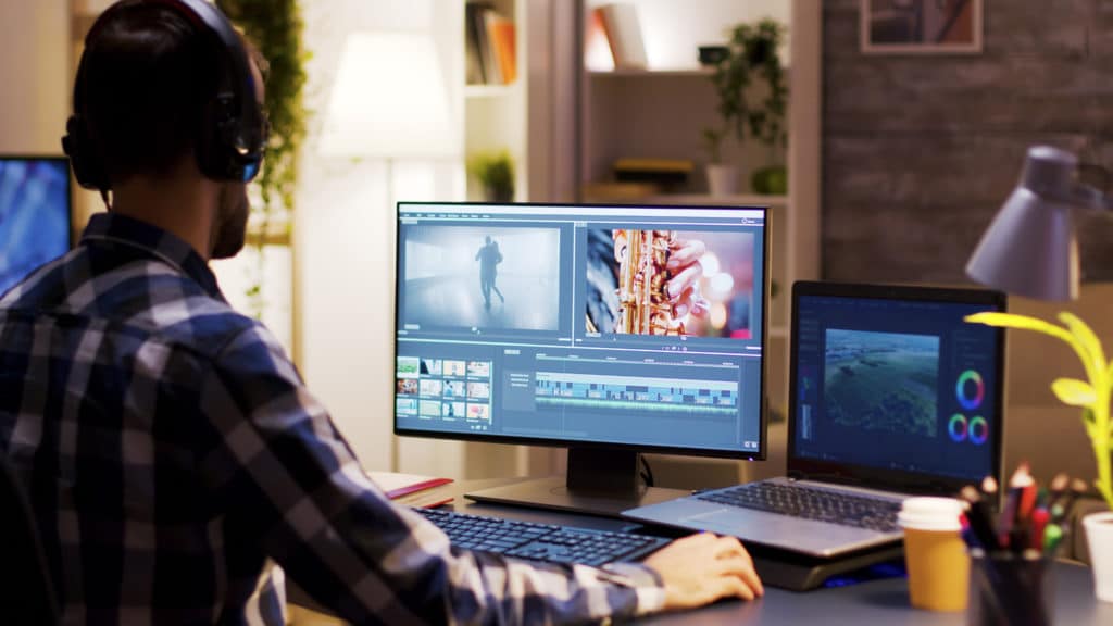 Film Maker Pointing At The Monitor In Home Office While