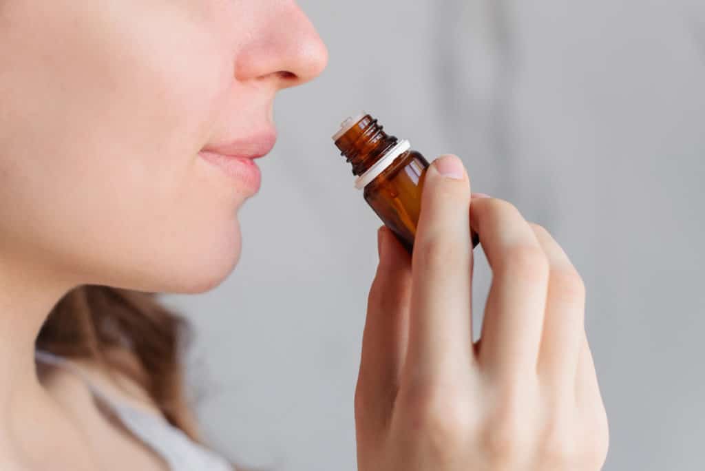 Aromatherapy: A Girl With Beautiful Skin Holds A Bottle Of