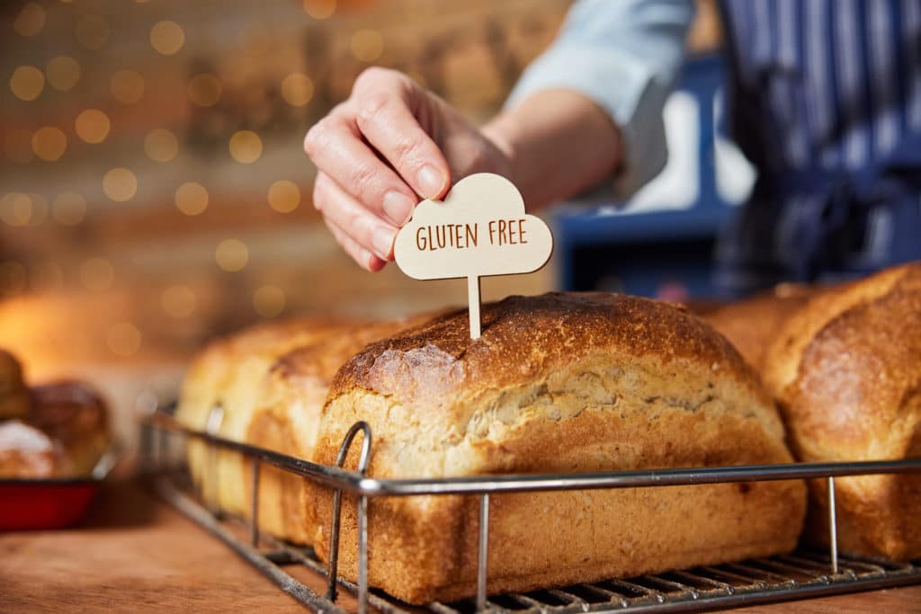 Sales Assistant In Bakery Putting Gluten Free Label Into Freshly
