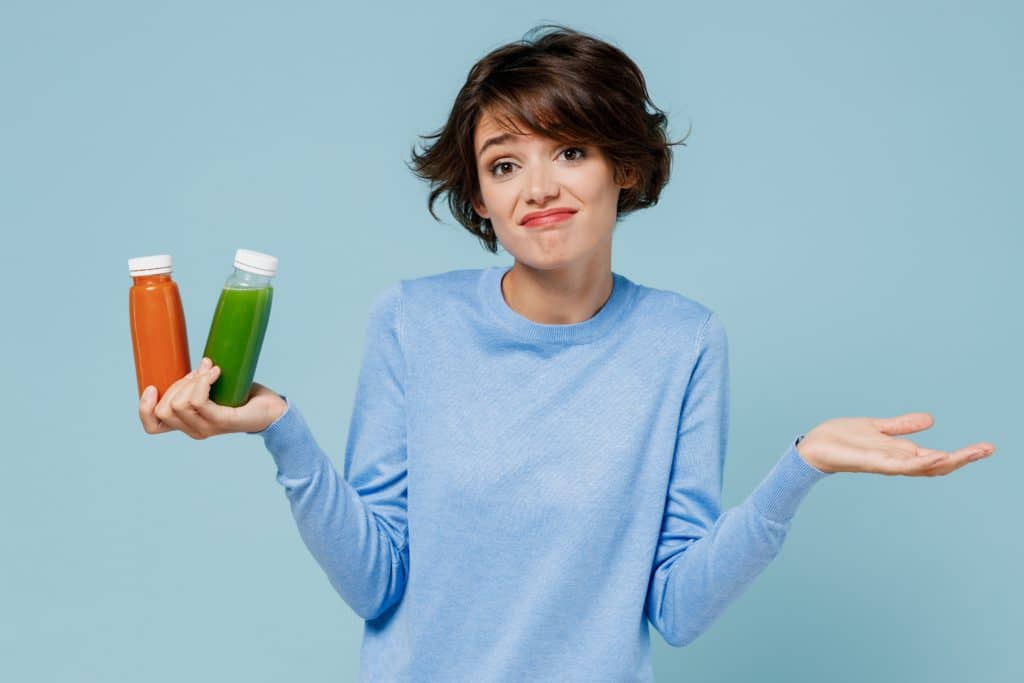 Young Confused Woman Wear Casual Sweater Hold Pressed Juice Green