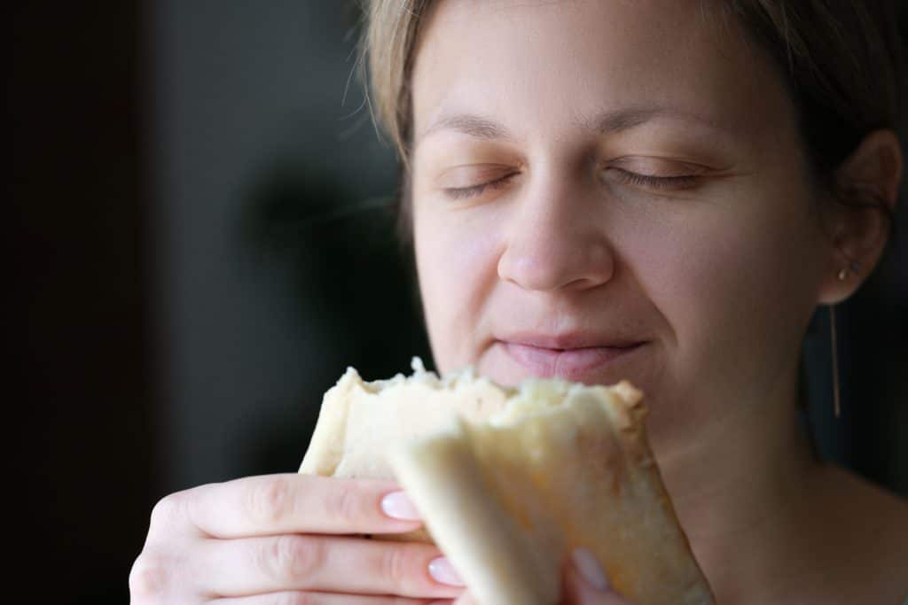 Happy Woman With Closed Eyes Holding White Bread. Cooking Delicious