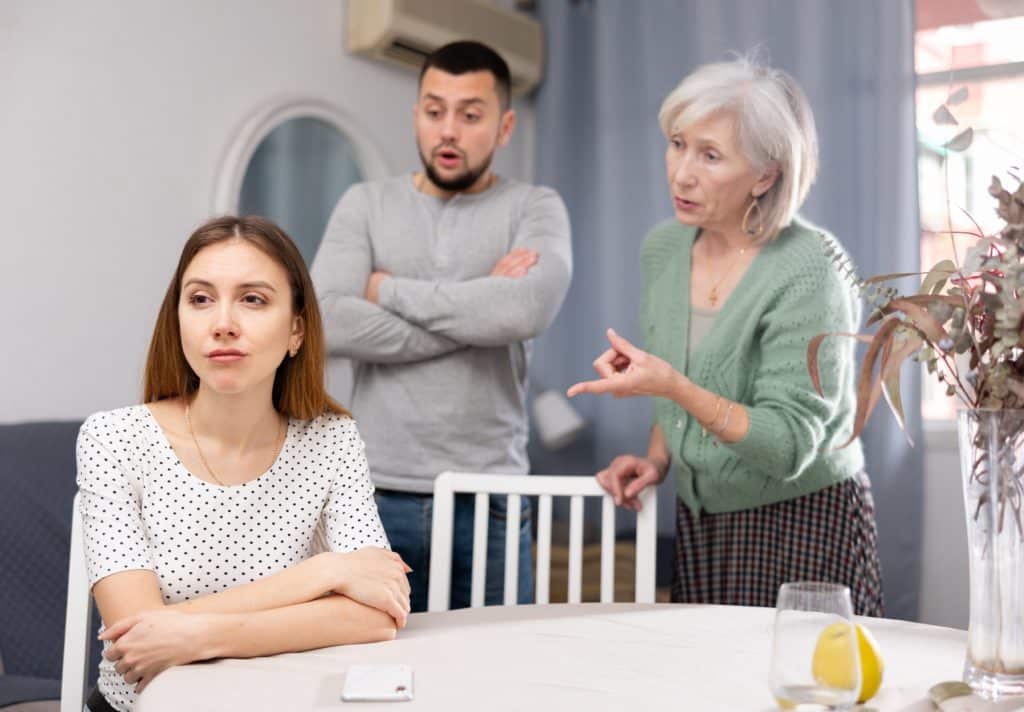 Woman Ignoring Her Husband And Mother In Law Standing Behind And Arguing