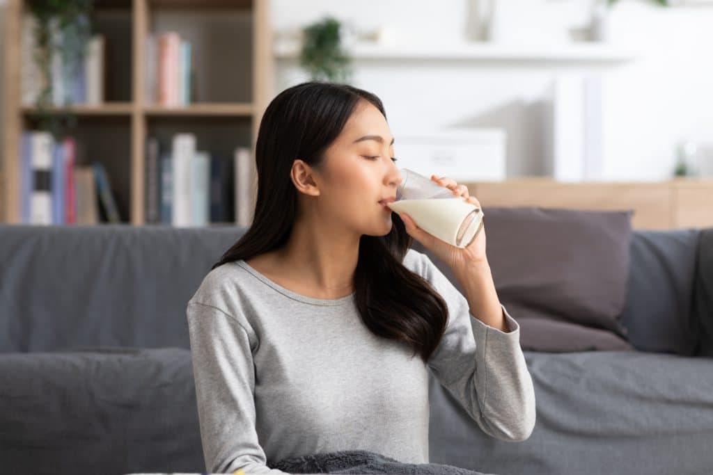 Healthy Young Asian Woman Drinking Milk With Calcium For Strong
