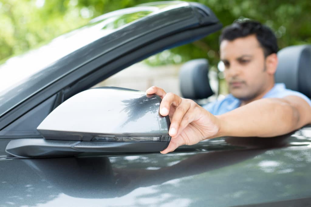 Closeup Portrait Young Man Driver Looking Adjusting Side View Car