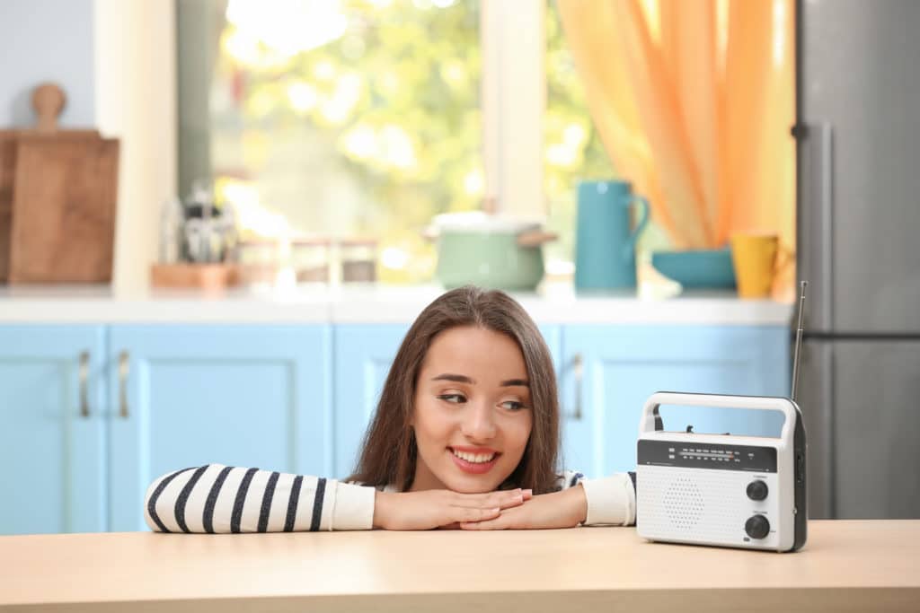 Young Woman Listening To Radio In Kitchen