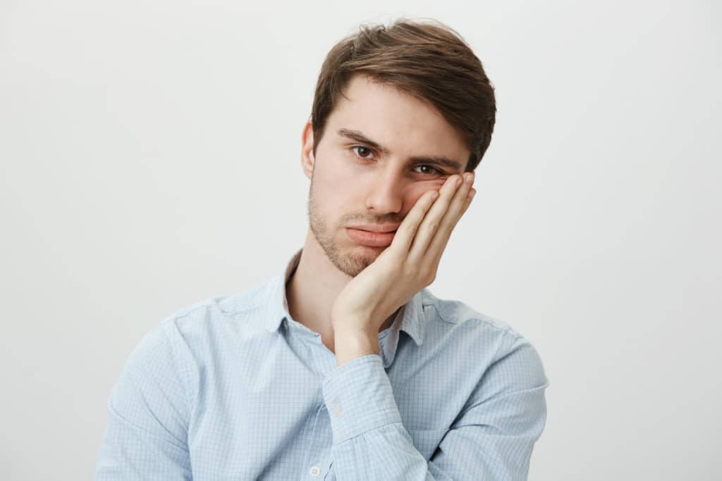 Indoor Shot Of Upset Irritated Caucasian Guy Leaning On Palm