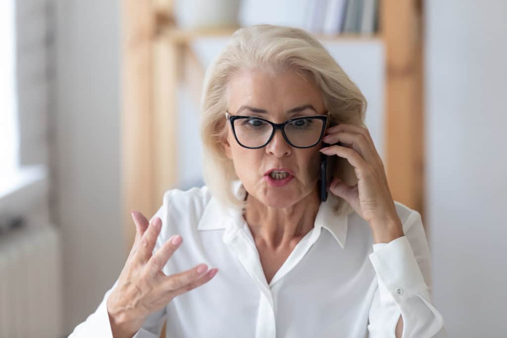 Outraged Mature Businesswoman Talking By Phone Arguing With Client Feels