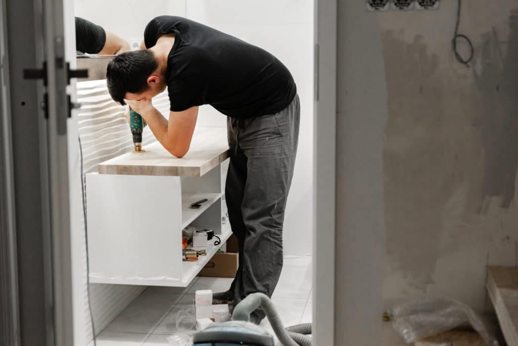 Man Drills A Washbasin Hole In The Bathroom Home Repair Work
