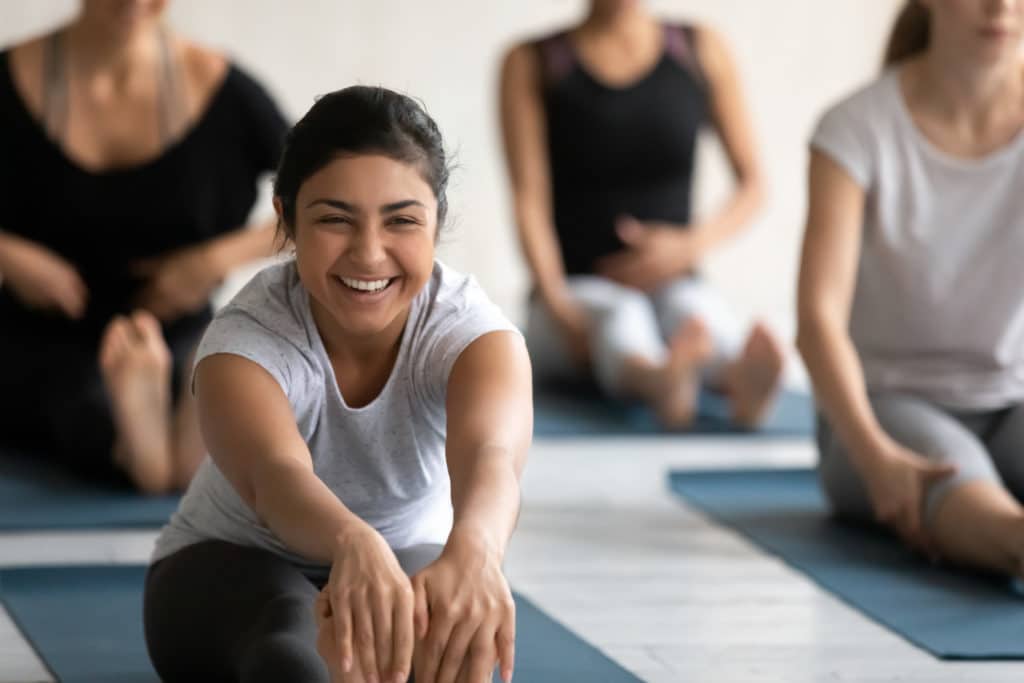 Happy Young Indian Woman Excited By Flexibility Progress In Seated