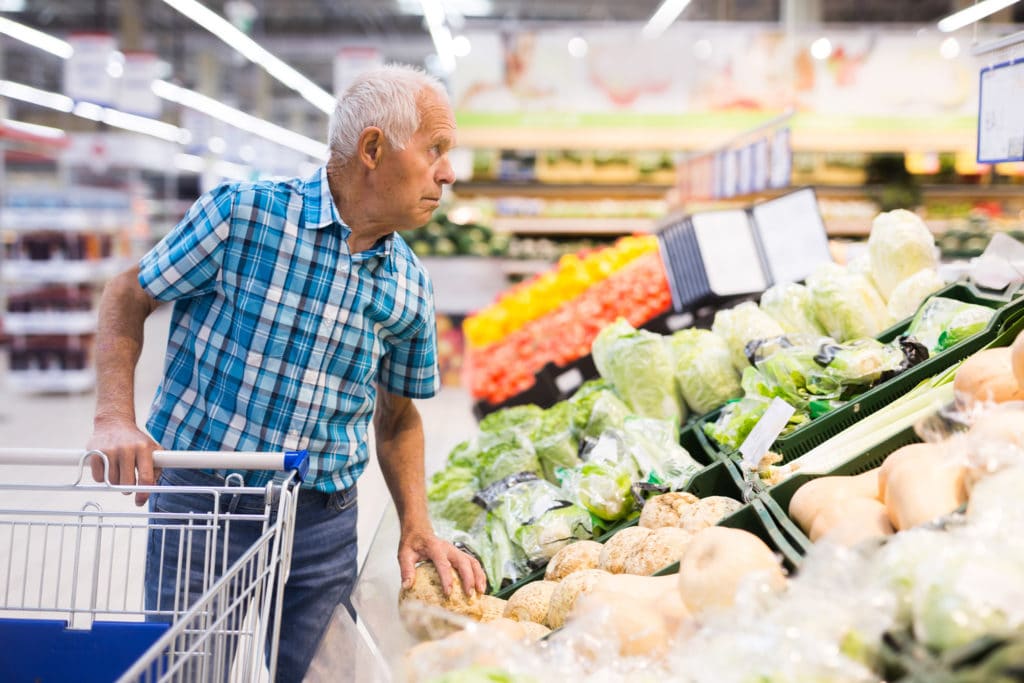 Elderly Retired Man Buying Turnip In Grocery Department Of Supermarket