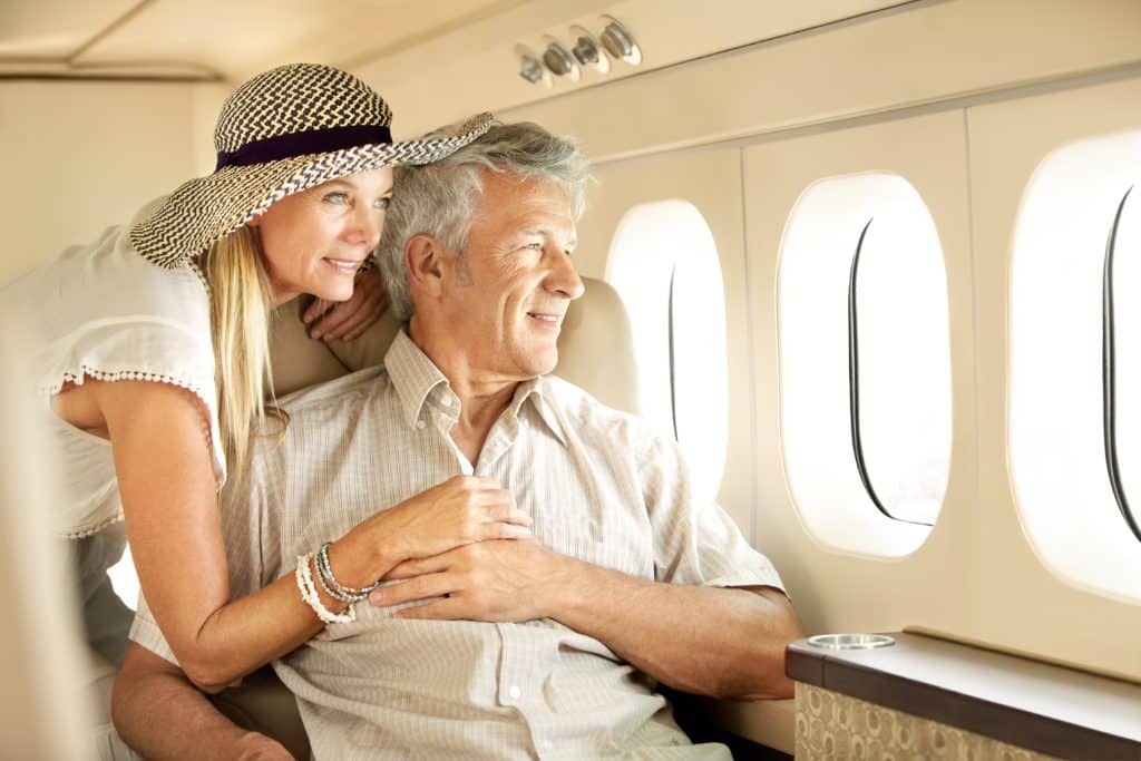 Taking A Luxury Trip. Smiling Senior Couple On An Airplane