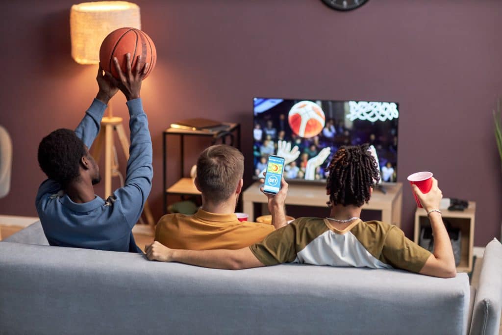 Back View At Group Of Friends Watching Basketball Match At