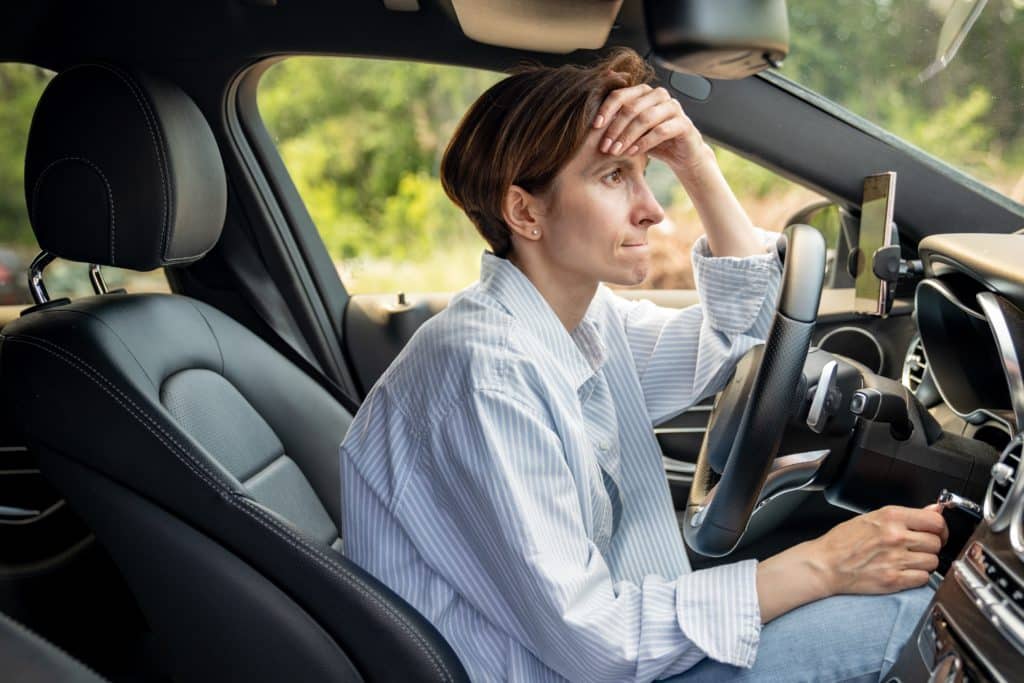 Stressed Middle Aged Woman Driving Car Having Problems On Road