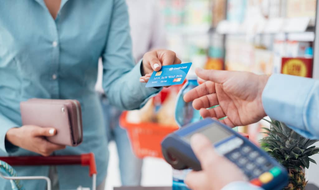 Woman At The Supermarket Checkout She Is Paying Using A