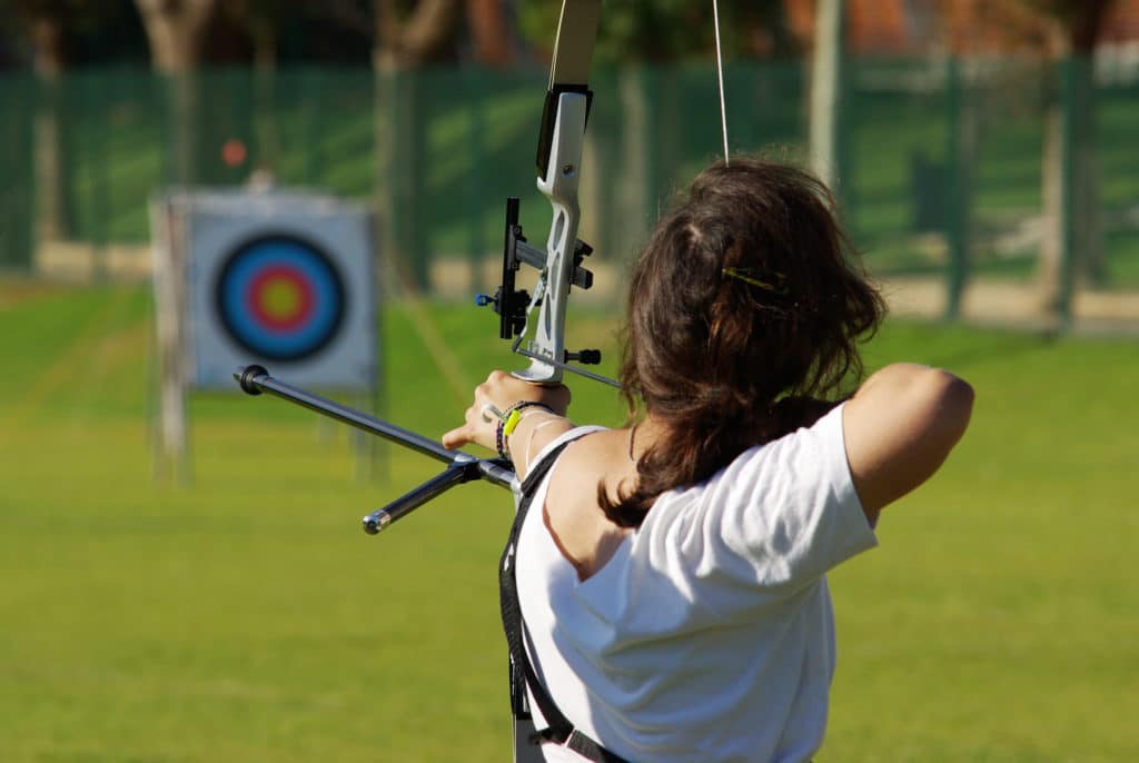Back Of Archery Athlete Aiming At A Target In The