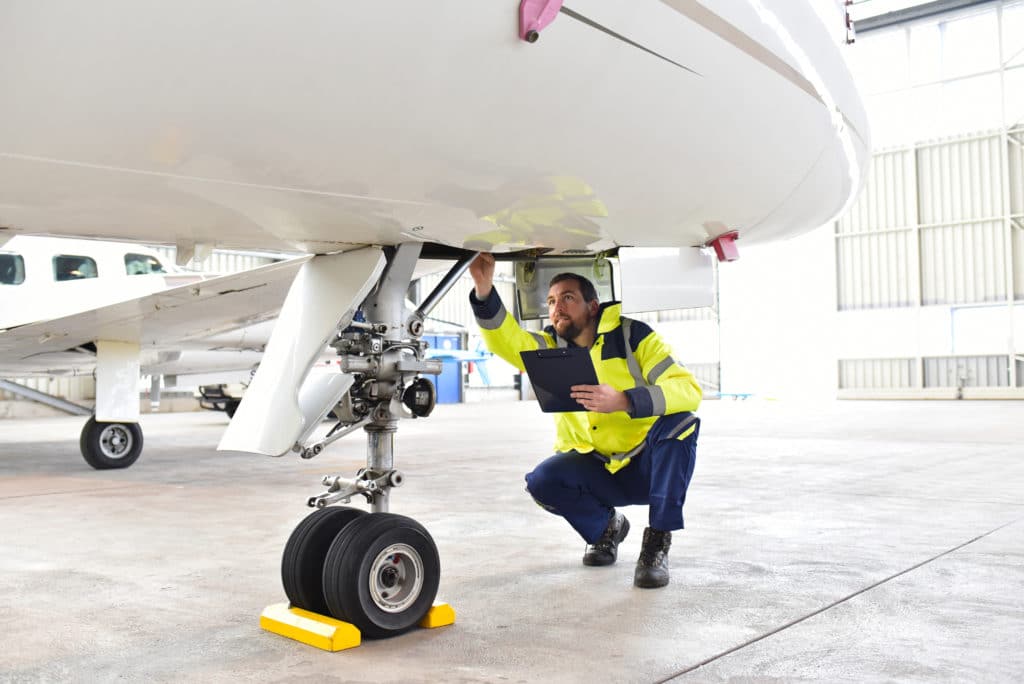 Ground Personnel At The Airport Check The Hydraulic System Of