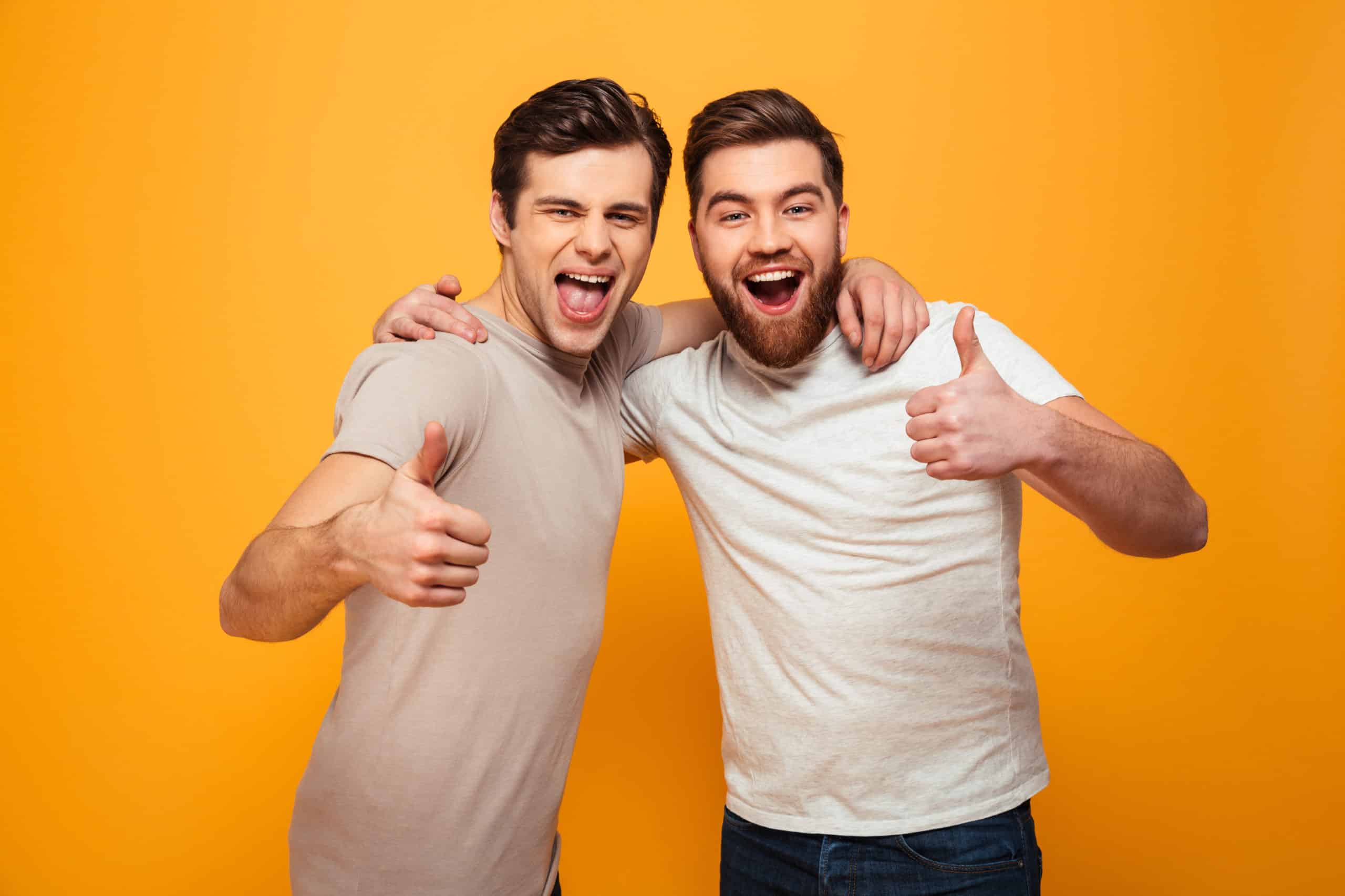 Portrait Of A Two Happy Young Men Showing Thumbs Up