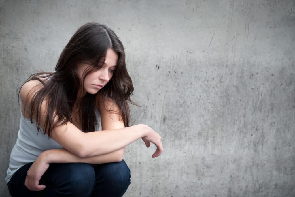 Outdoor Portrait Of A Sad Teenage Girl Looking Thoughtful About