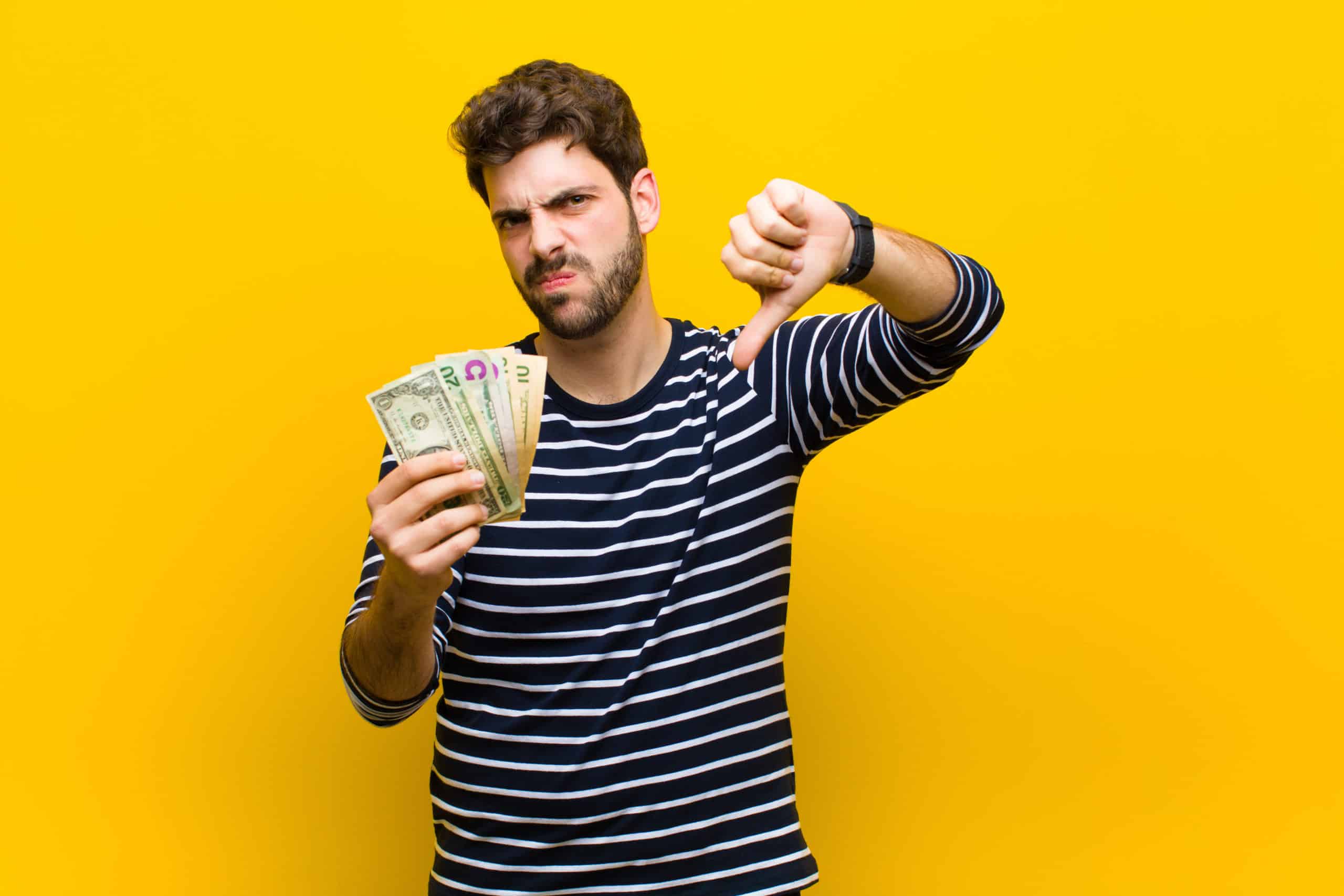 Young Handsome Man With Dollar Banknotes Against Orange Background