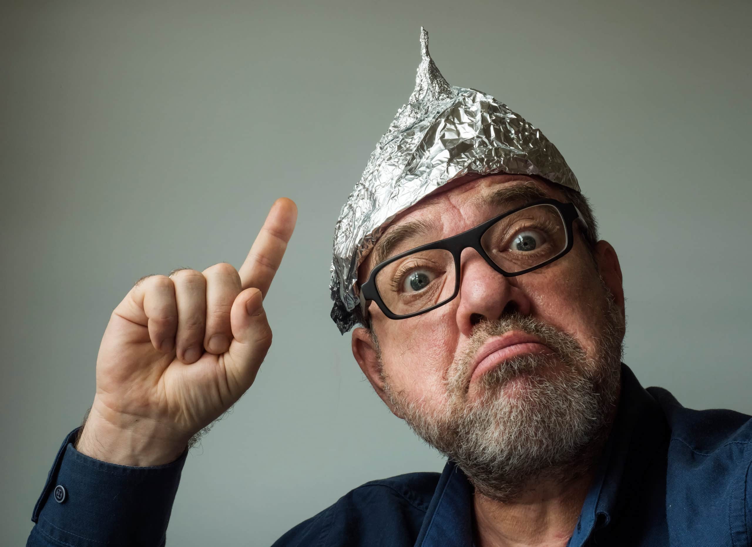 Strange Stupid Man Conspiracy Theorist In Protective Foil Cap. Fake