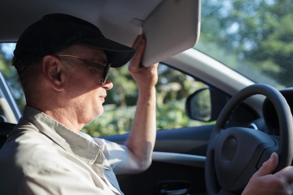 Side View Of An Old Man At The Wheel Trying