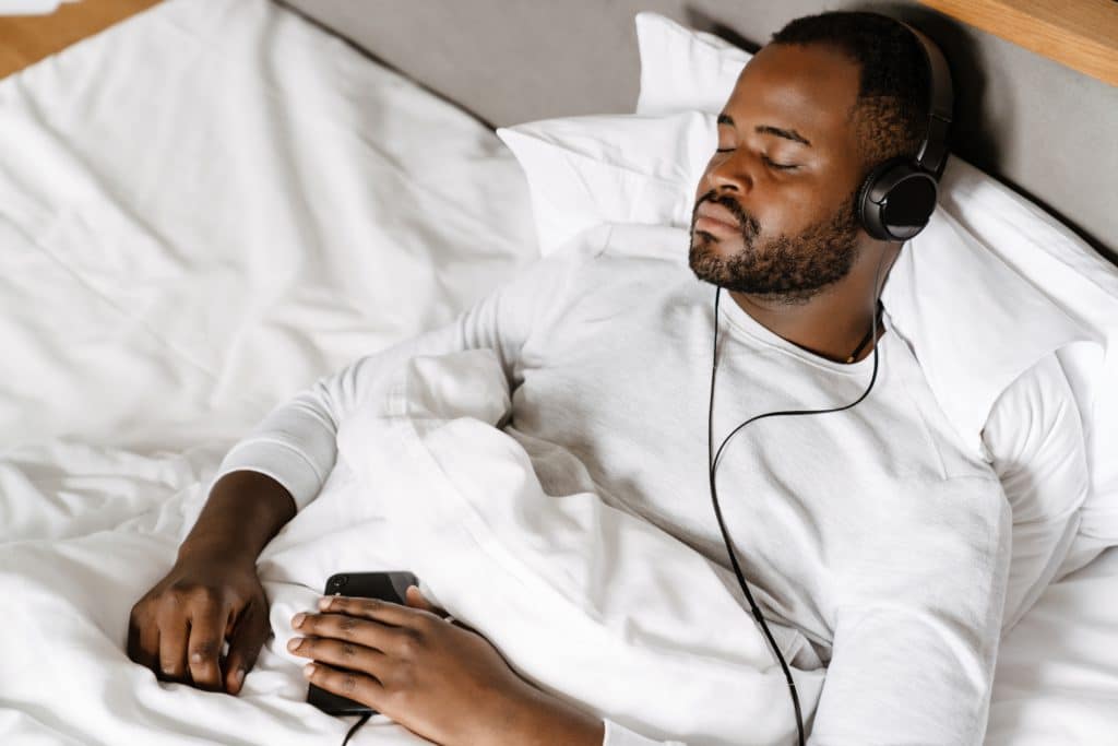Black Bristle Man Listening Music While Sleeping In Bed At