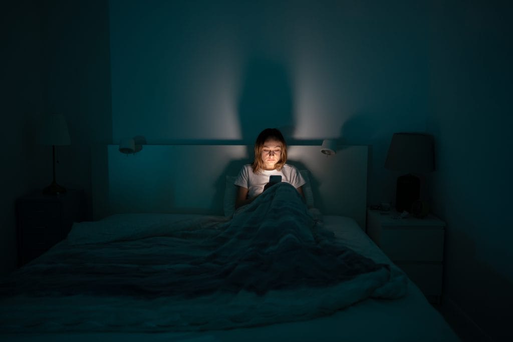 Sleepy Exhausted Woman Lying In Bed Using Smartphone Can Not