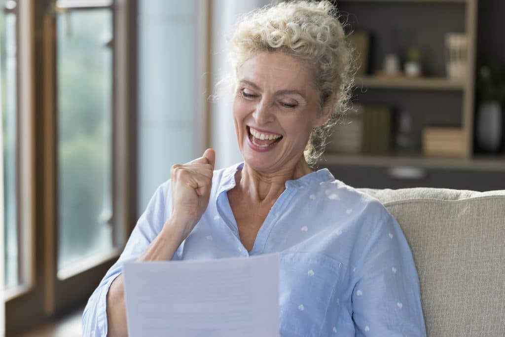 Cheerful Happy Mature Woman Reading Paper Letter Holding Legal Document 