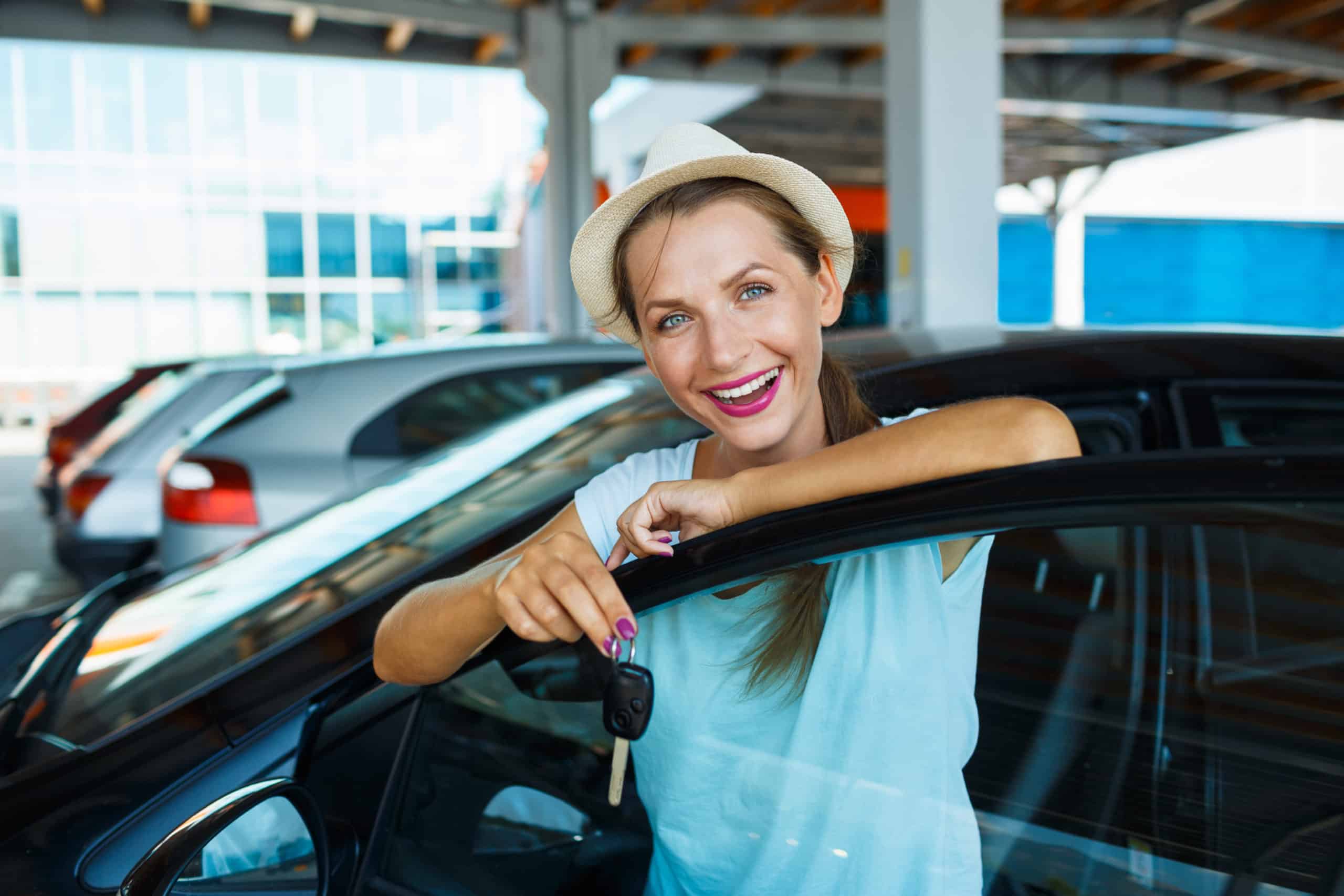Young Happy Woman Standing Near A Car With Keys In