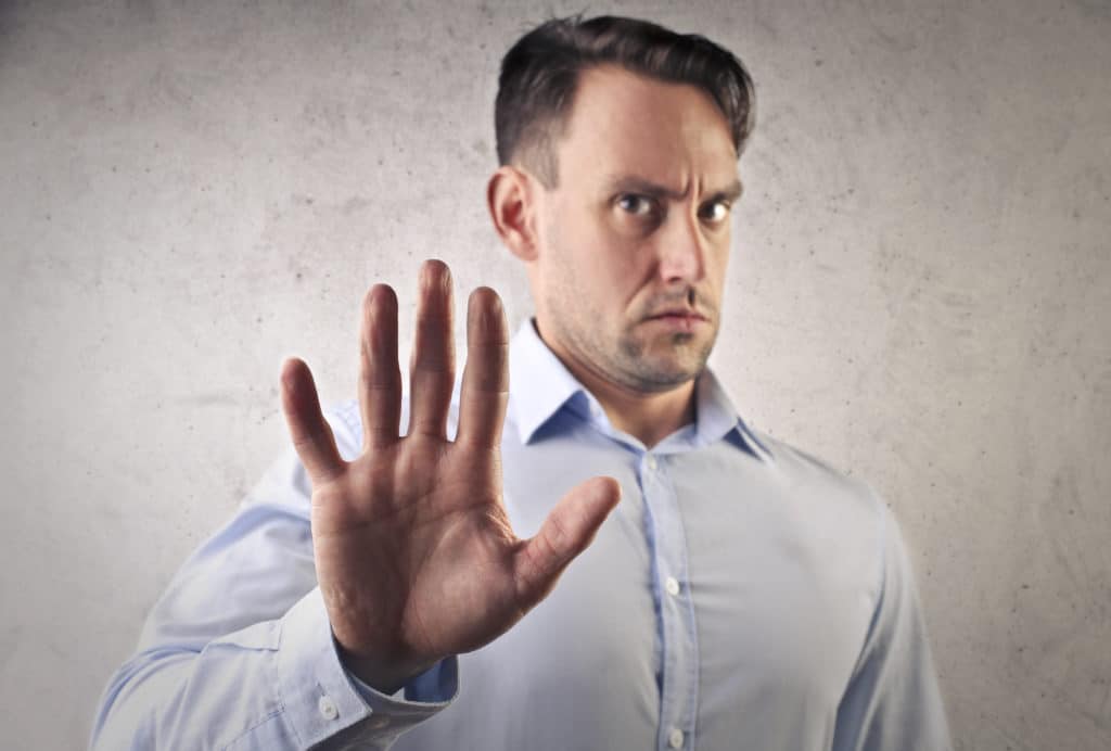 Man In Blue Shirt Saying Stop With His Hand