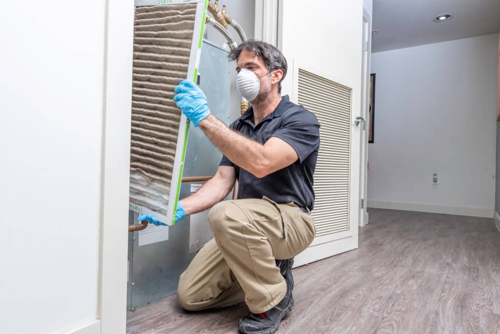 Hvac Maintenance Technician Removing A Diry Air Filter From A