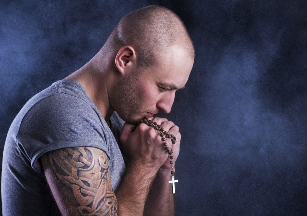 Handsome Young Man With Tattoo Isolated On Black.