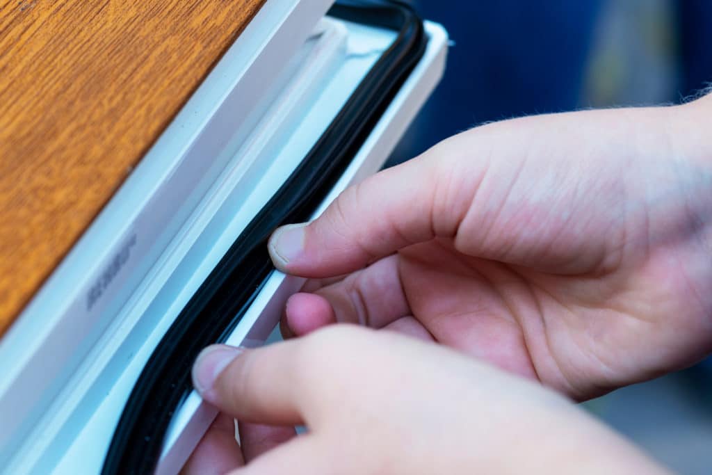 Hands Applying Rubber Strip. Concept Improvement Of Sealing Sound Insulation