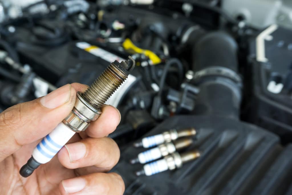 Hand Of The Auto Mechanic Holding The Old Spark Plug