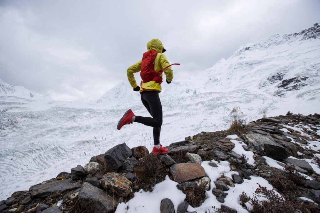 Woman Trail Runner Cross Country Running Up Hill To Winter