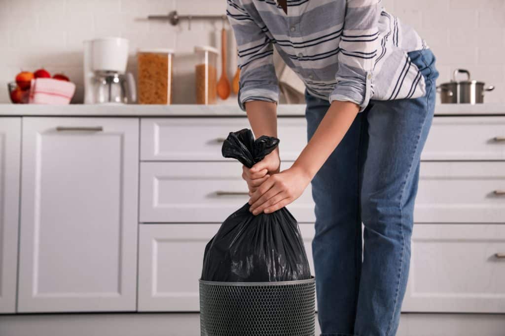 Woman Taking Garbage Bag Out Of Bin At Home Closeup
