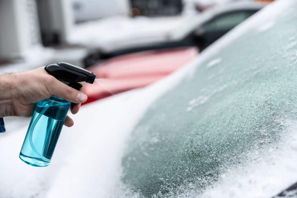 Man Uses A Bottle Of De Icer To Defrost The Ice Covered