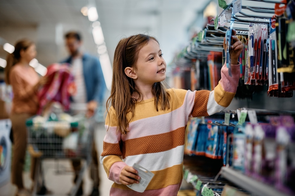 Smiling Little Girl Buying School Supplies While Being With Her