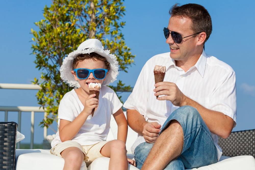 Father And Son Relaxing Near A Swimming Pool At The